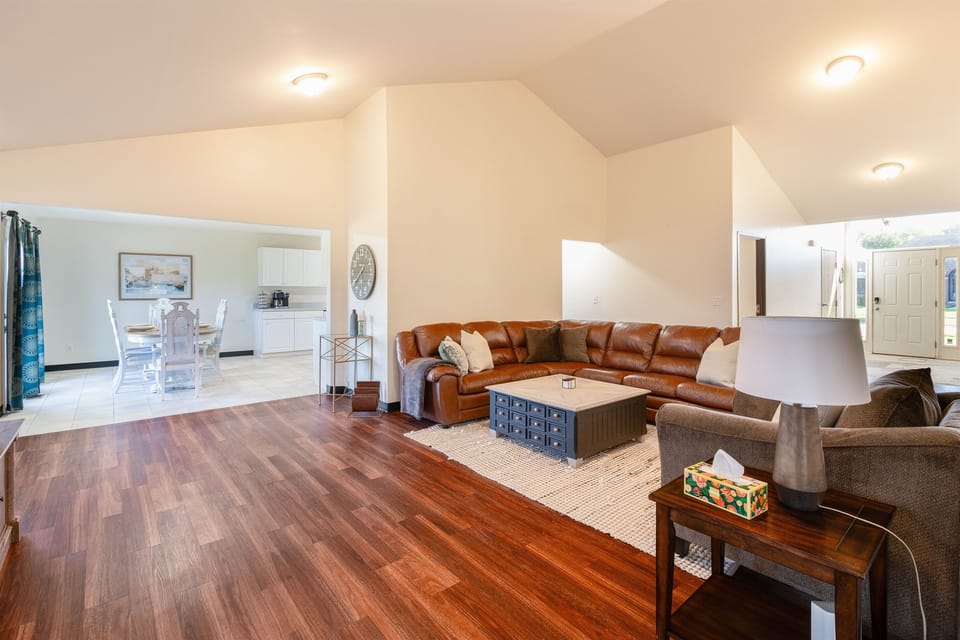This spacious living area radiates warmth and comfort with its plush seating arrangements and well-lit ambiance. It's a welcoming space designed for hours of relaxation, entertainment, or engaging conversation.