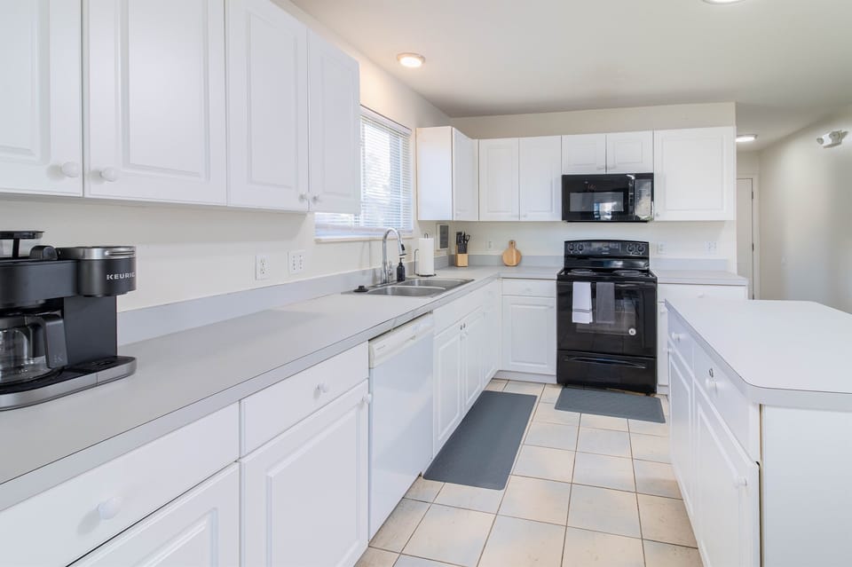 This modern kitchen features top-of-the-line appliances and ample counter space, making it a chef's dream. The tasteful design and lighting create an inviting and functional space perfect for culinary exploration.