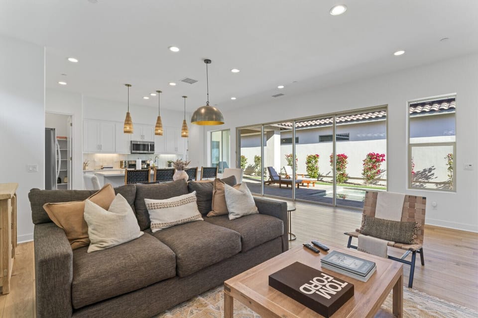 Bright open-concept living area w/ plush sectional & seamless flow to the patio