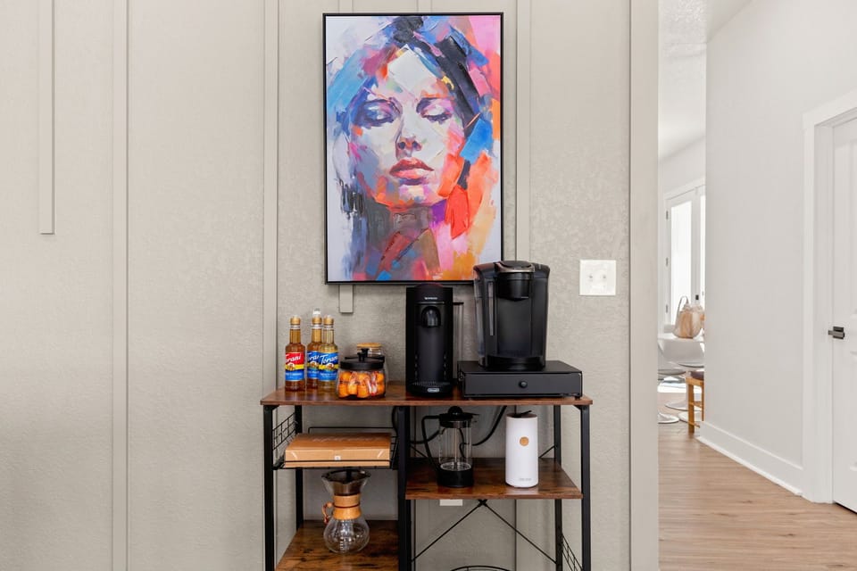 Coffee bar includes  a keurig coffee maker, a pour-over coffee maker, a french press + regular coffee, coffee pods, tea, sugar, cream, and sweetener.