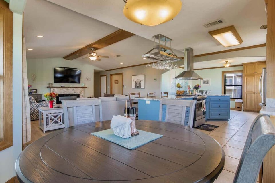 Open-concept living room, kitchen, and dining area designed for comfort in this Grande Lagoon vacation rental near Perdido Key. Enjoy Smart TVs, a fully equipped kitchen, and space for shared meals just minutes from Johnson Beach and NAS Pensacola.