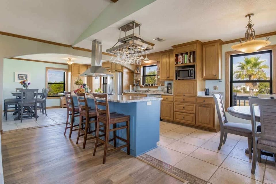 Open-concept living room, kitchen, and dining area designed for comfort in this Grande Lagoon vacation rental near Perdido Key. Enjoy Smart TVs, a fully equipped kitchen, and space for shared meals just minutes from Johnson Beach and NAS Pensacola.