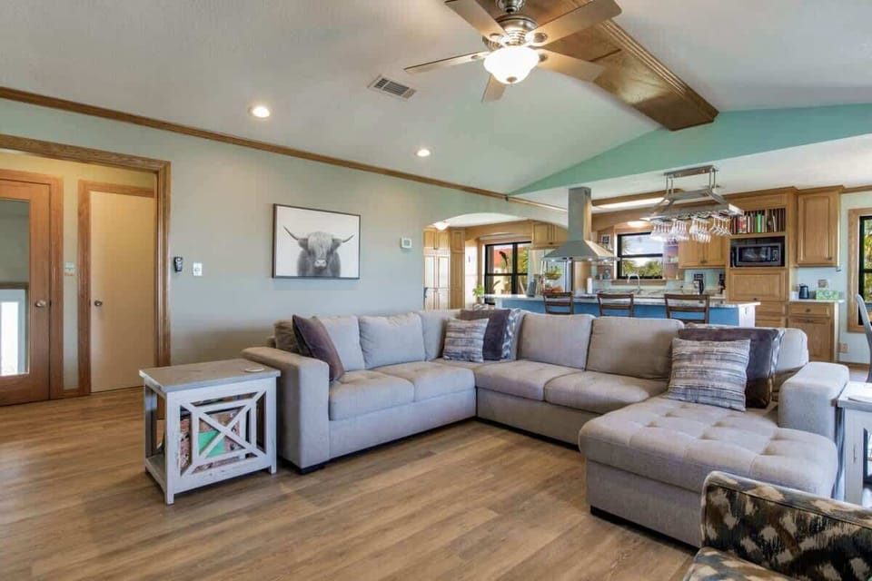 Open-concept living room, kitchen, and dining area designed for comfort in this Grande Lagoon vacation rental near Perdido Key. Enjoy Smart TVs, a fully equipped kitchen, and space for shared meals just minutes from Johnson Beach and NAS Pensacola.