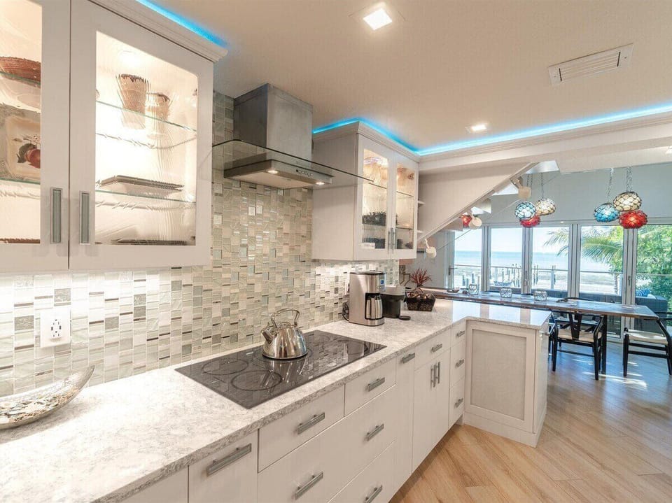 High-end chef's kitchen with induction cooktop, pizza oven, and premium coffee stations.