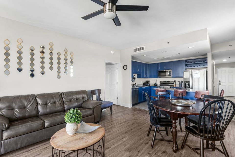 Open-concept living and dining area with modern blue kitchen cabinets and hardwood floors.
