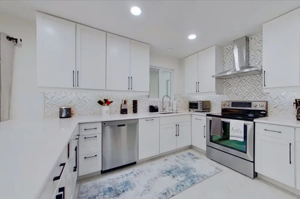 Large fully equipped kitchen with stainless steel stove, vent, dishwasher
