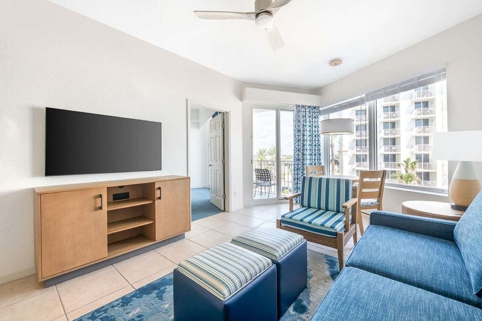 Living Area • Blue Sofa, Striped Seating & Balcony Views