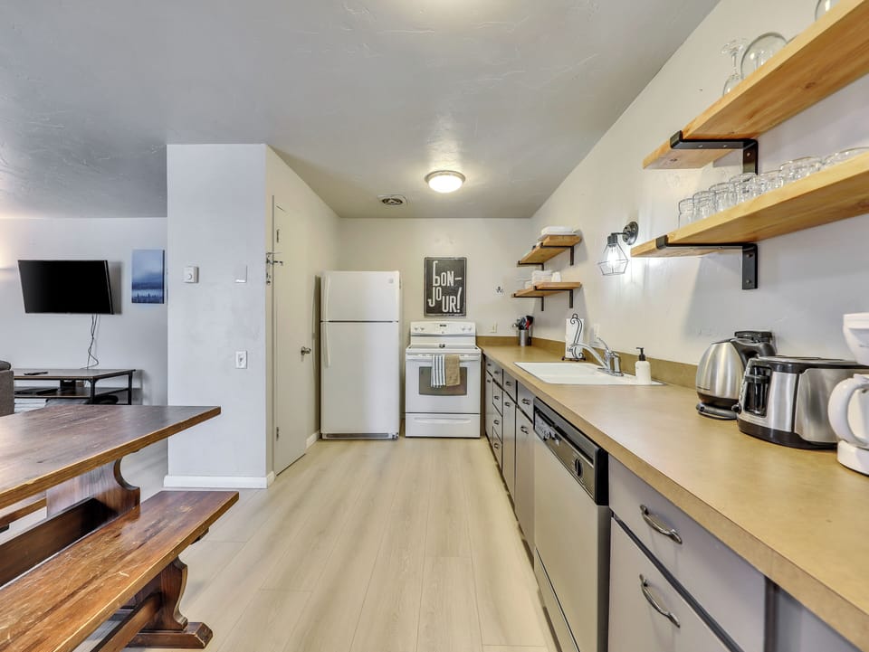 View of the fully loaded upgraded kitchen with open shelving and new flooring