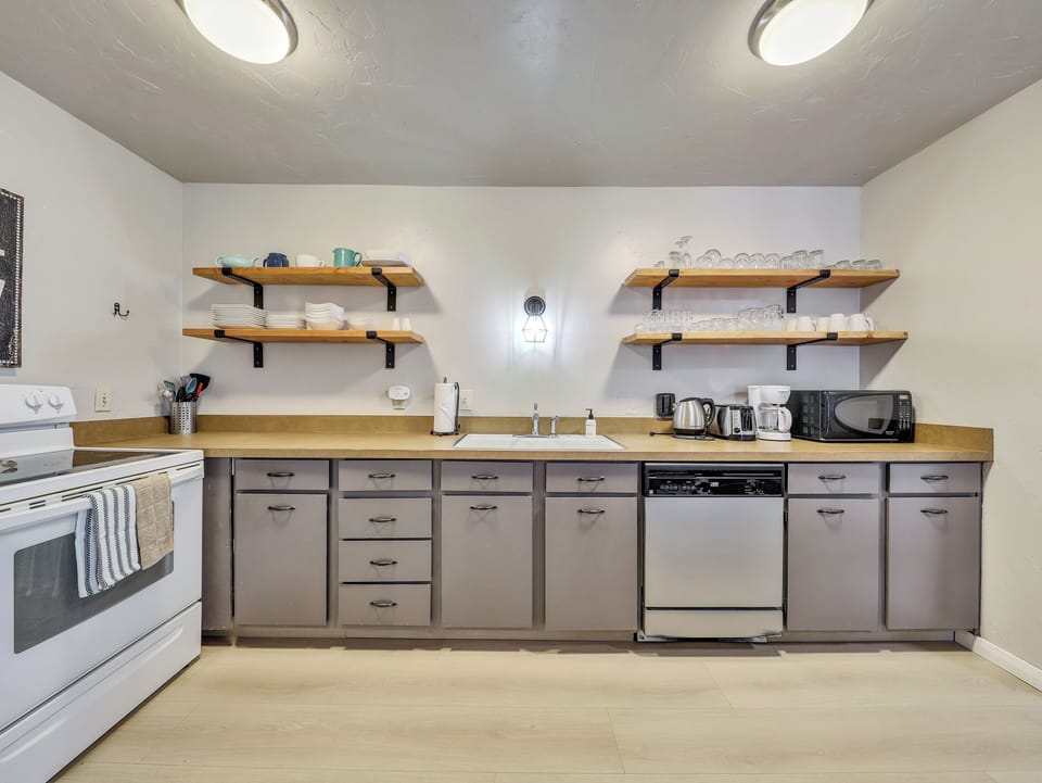 View of the fully loaded upgraded kitchen with open shelving and new flooring