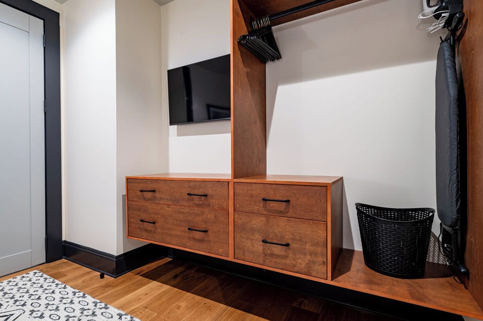 Bedroom 3 - Closet space equipped with hangers, laundry hamper, and iron with ironing board.