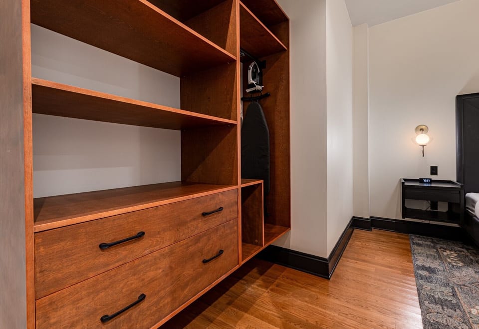 Bedroom 2 - Closet space equipped with hangers, laundry hamper, and iron with ironing board.