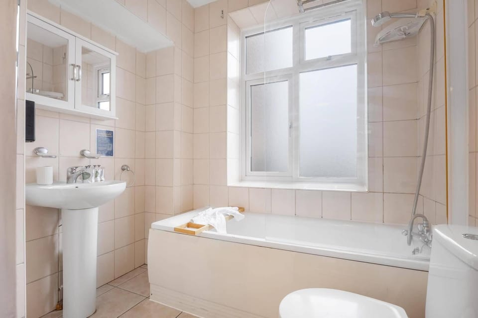 Modern bathroom featuring both a bathtub and separate shower, complete with fresh towels and complimentary toiletries for a relaxing stay