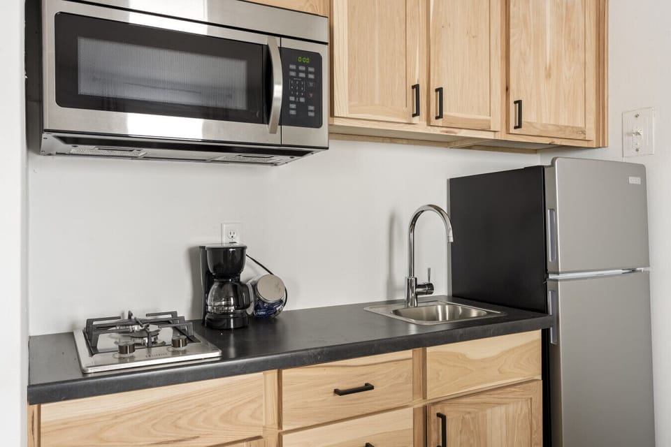 Compact kitchen counter offering a gas range and microwave oven.