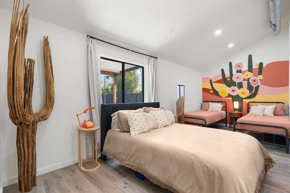 Calm bedroom with a neutral, layered bed and a playful mural—unwind in soft tones, then wake up to daylight spilling through the window.