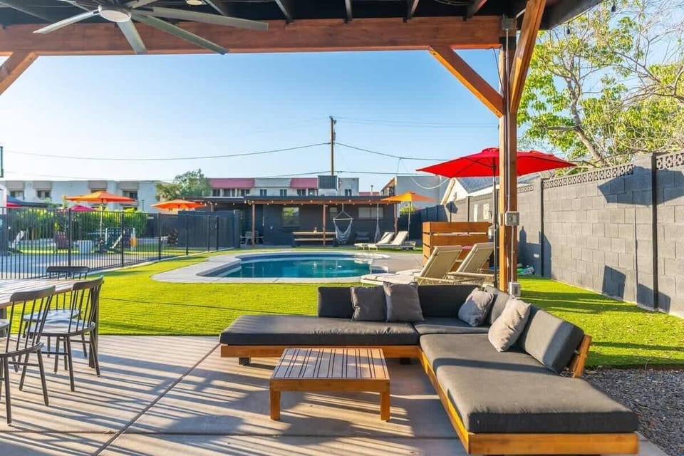 Shaded patio with cushioned seating and a coffee table—kick back under the cover, then take in courtyard and pool views with pops of color from the umbrellas.