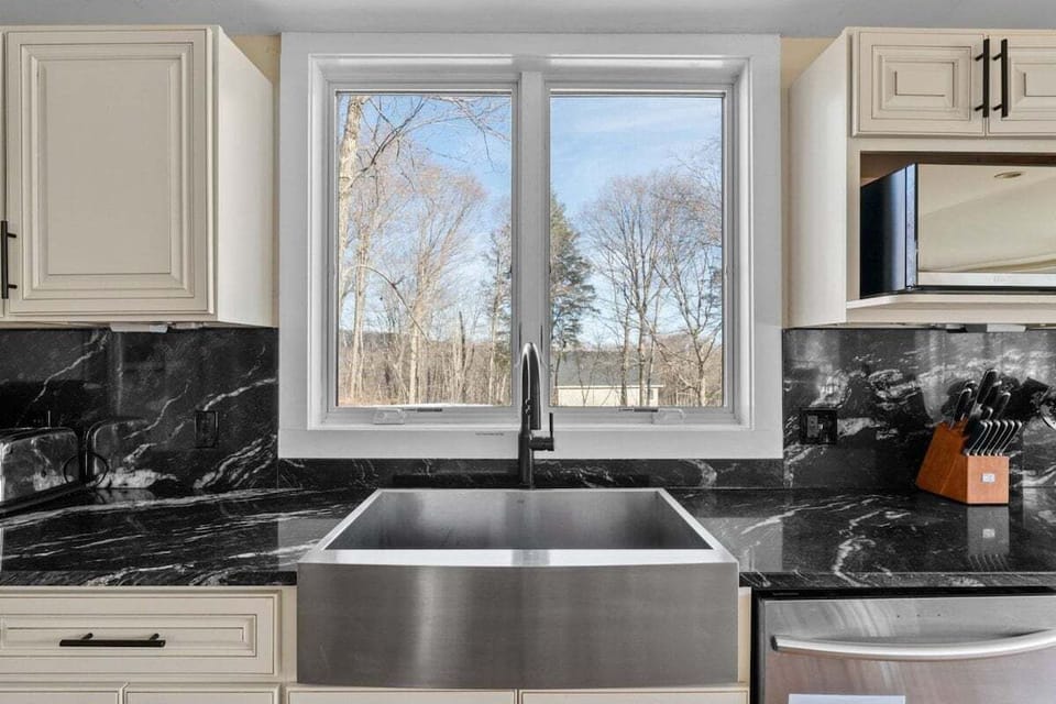 Wash up at the deep sink while looking out through the wide kitchen window.