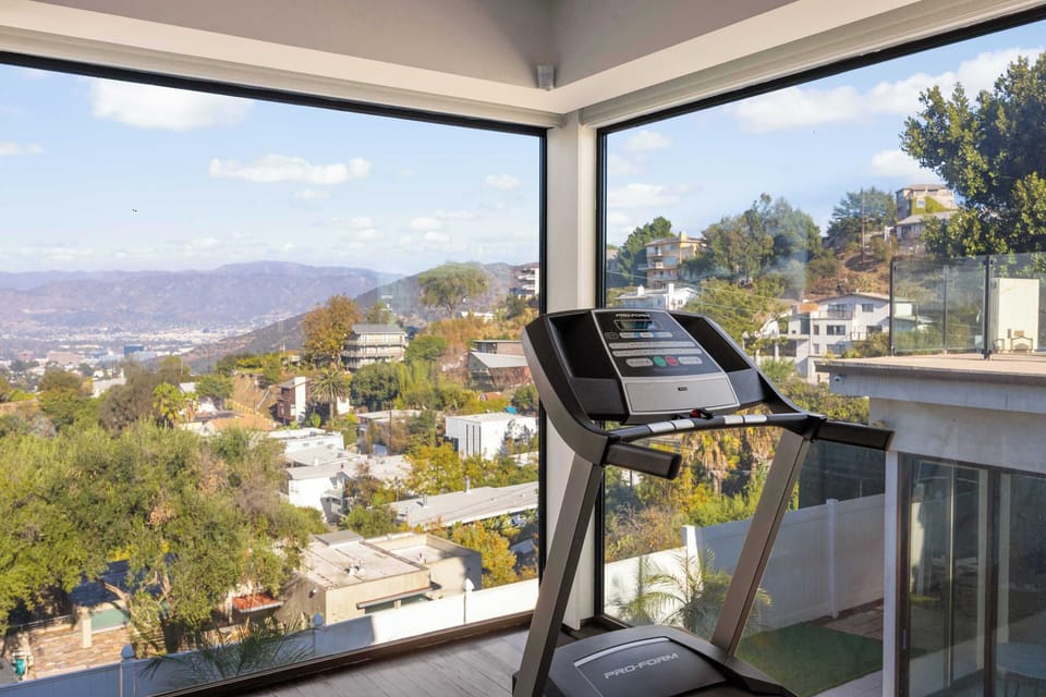Primary Suite: Treadmill with Floor-to-Ceiling Corner Windows & Hollywood Hills View