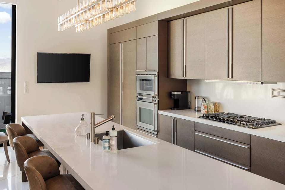 Kitchen Detail: White Quartz Island, Gas Range, Double Oven & Bar Stools