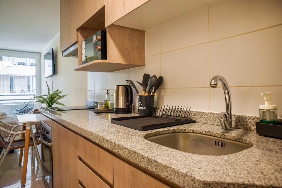 Modern kitchenette with sleek appliances and cozy dining area, perfect for a comfortable stay in the heart of the city.