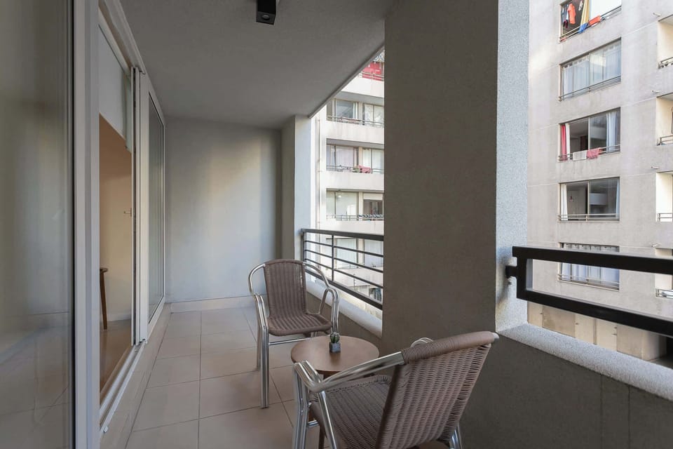 Unwind on the cozy balcony with a drink, surrounded by city views and fresh air.