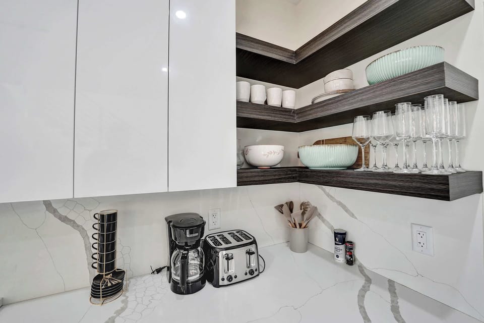 Start your day with ease in this thoughtfully stocked kitchen, featuring modern conveniences like a coffee maker, toaster, and hot water kettle.