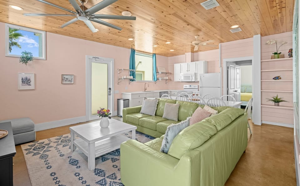 Full Open Plan — Green Sectional, Kitchen, White Dining Table & Front Entry