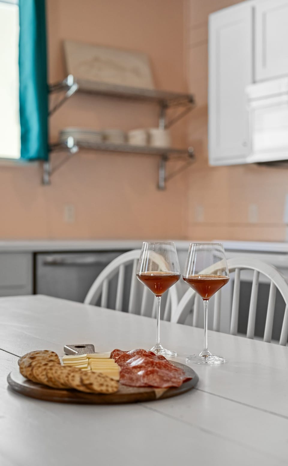 Charcuterie Detail — Cheese & Salami Board with Two Glasses of Rosé on Farmhouse Table