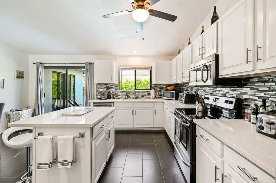New countertops and backsplash, large refrigerator and freezer, espresso maker, coffee maker, tea kettle, dishwasher, sink and microwave.