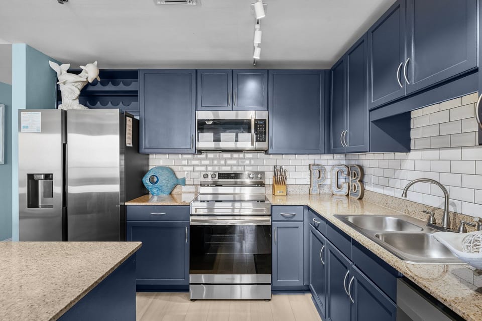 Modern kitchen with navy blue cabinetry and stainless steel appliances