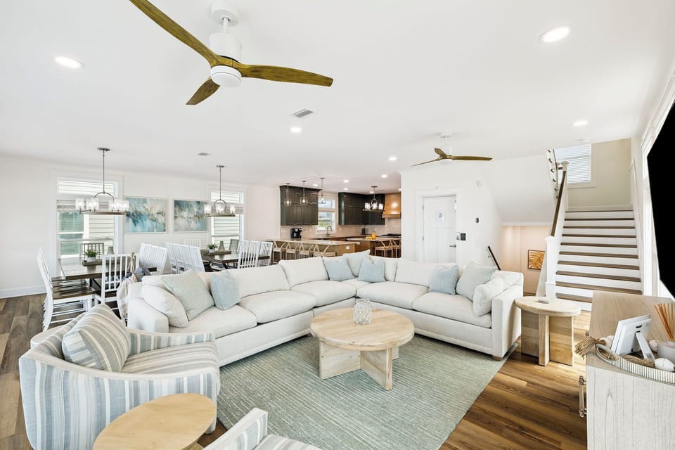 You'll love the bright, open flow of this inviting living area, where soft coastal colors, cozy seating, and natural wood tones create your perfect home-away-from-home retreat.