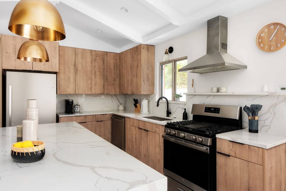 Bright, modern kitchen with wood cabinetry, quartz countertops, and a spacious island — a perfect blend of style and function