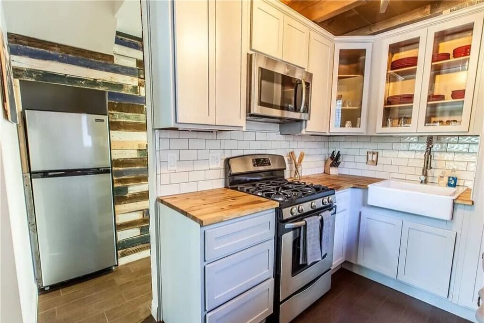Full kitchen with gas range, fridge & subway tile backsplash