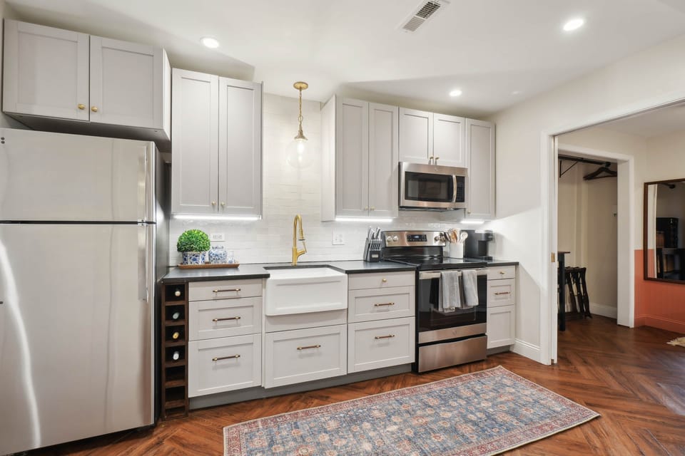 The fully-equipped kitchen includes a four-burner range, full fridge and freezer, and dishwasher.