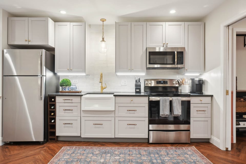 The fully-equipped kitchen includes a four-burner range, full fridge and freezer, and dishwasher.