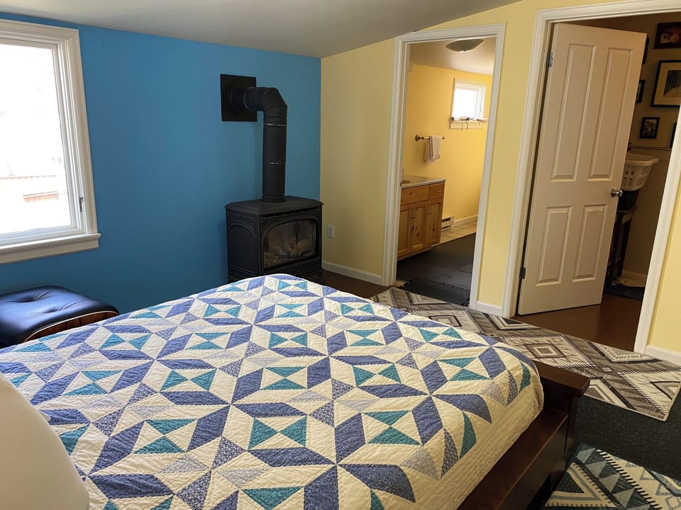 A wood stove highlights a bedroom.
