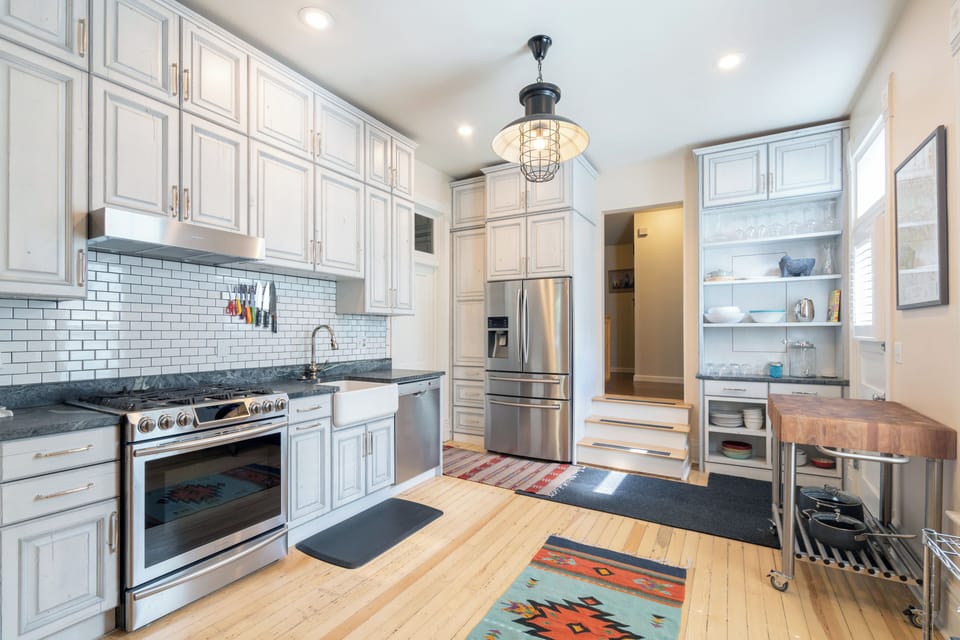 The kitchen of this holiday home in Telluride, with stainless steel appliances and a mobile kitchen counter table.