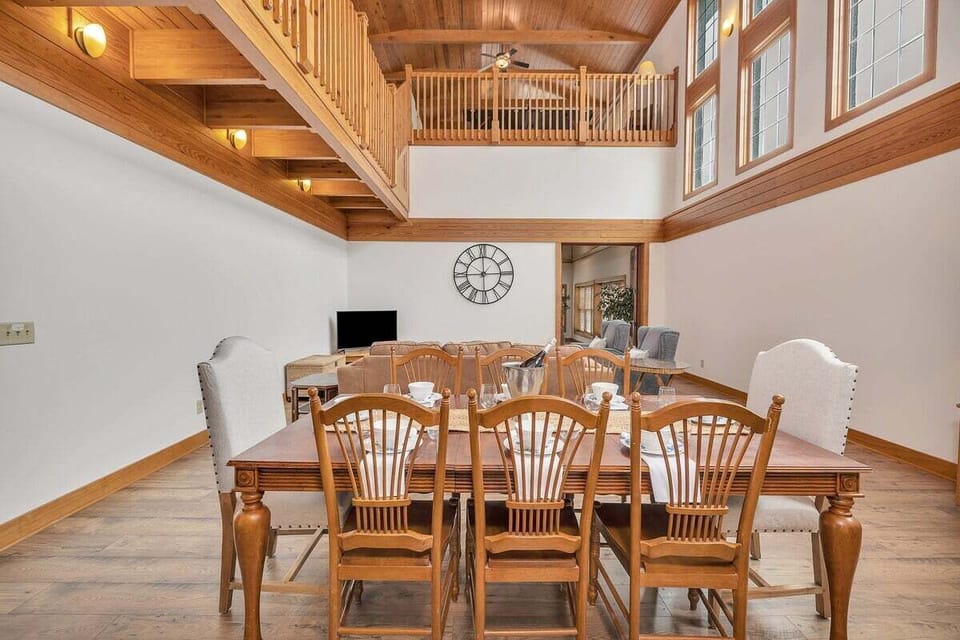Two-story great room with dining table and upper balcony