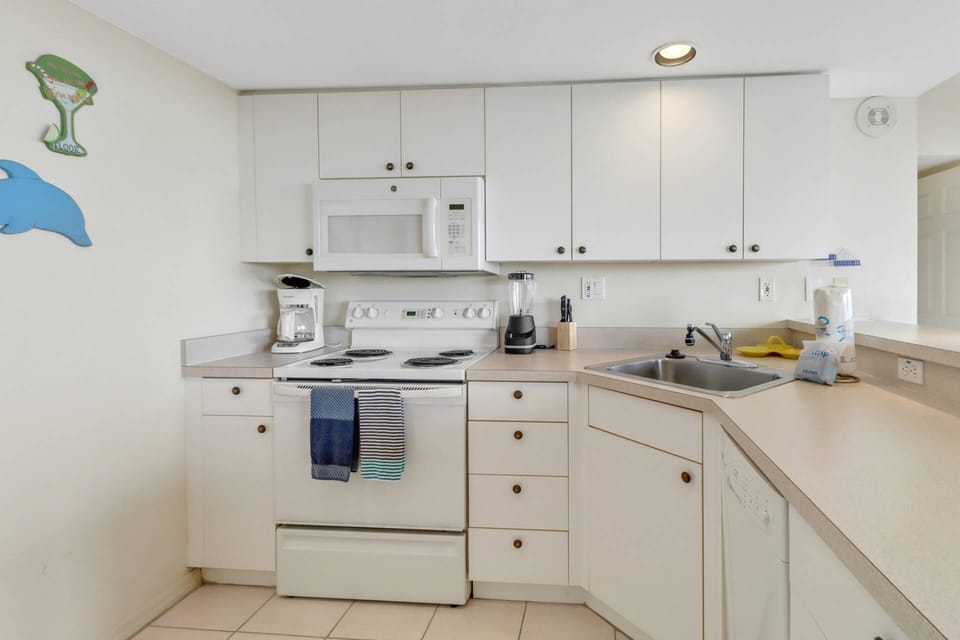 The kitchen is equipped with full size appliances, including an oven, microwave, refrigerator/freezer and dishwasher.