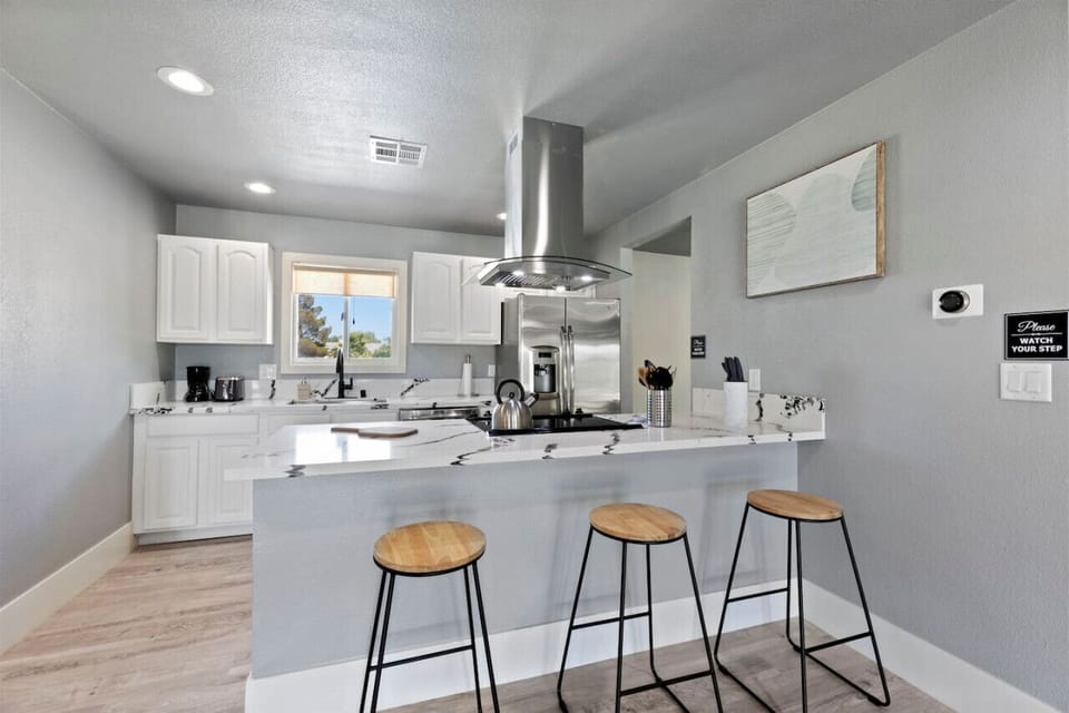 A stylish kitchen with sleek countertops, stainless steel appliances, and essential utensils