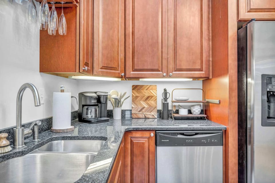 A clean, modern kitchen setup showcasing essential comforts. A well-fitted sink, high-quality appliances, and a convenient coffee maker.