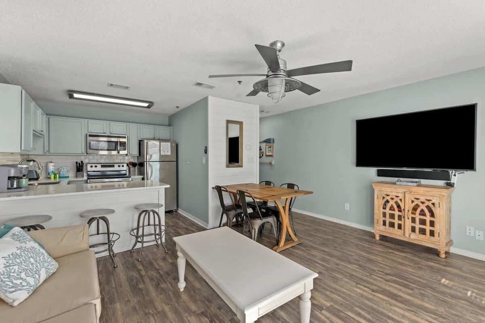 The living room includes the dining area, which seats 4, and the kitchen island which boasts 3 additional seats.