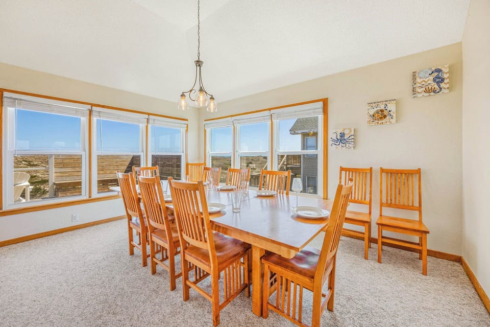 Gather around this welcoming dining table with seating for ten and picture yourselves sharing meals while panoramic coastal views stretch across the horizon through expansive windows.