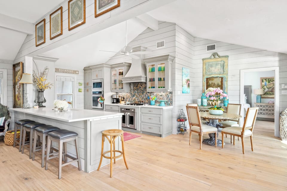 Bright kitchen with barstool seating, spacious peninsula & coastal backsplash.
