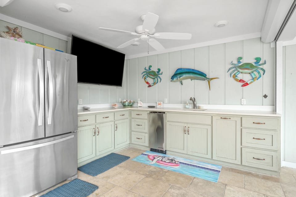 Ground-floor kitchen by the pool with fridge & counter space for gatherings.