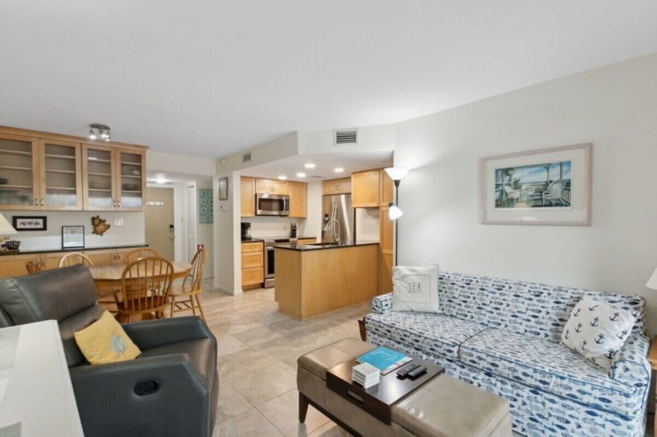 Bright open living space connecting the kitchen, dining area, and comfortable seating.