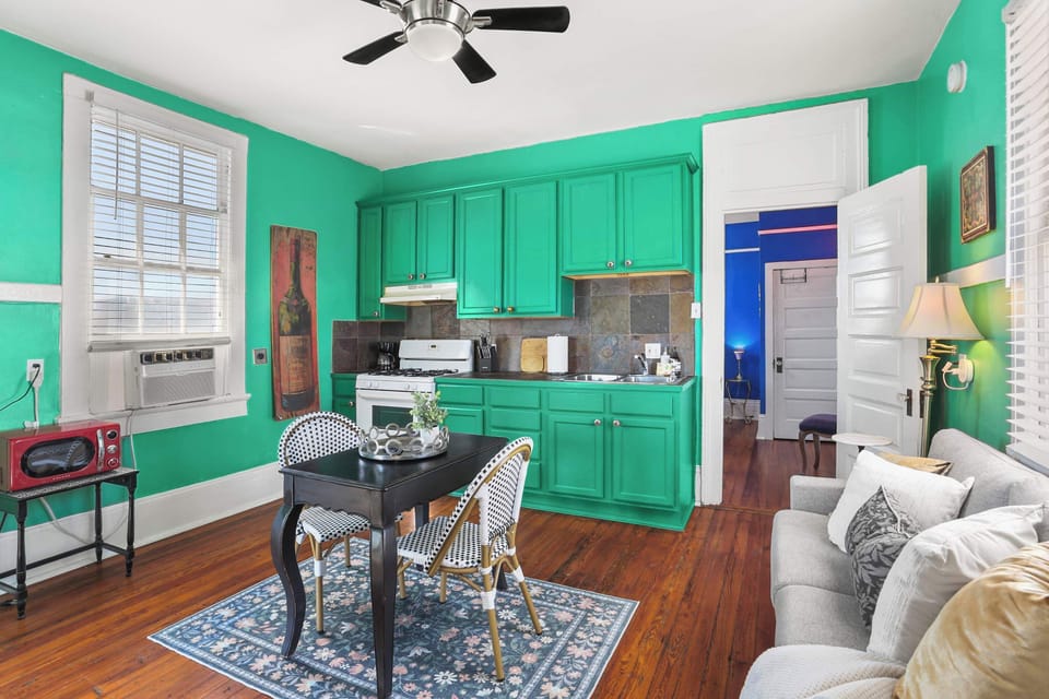 Eat-in kitchen/ Living area featuring a fridge/freezer, full-sized stove, oven, microwave, sink, dining table, sofa, and smart TV