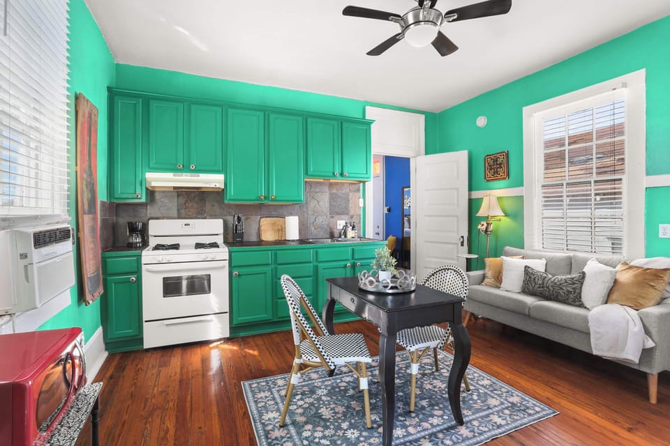 Eat-in kitchen/ Living area featuring a fridge/freezer, full-sized stove, oven, microwave, sink, dining table, sofa, and smart TV