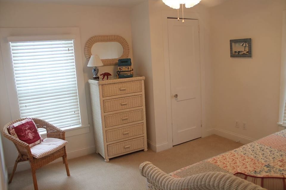 Charming bedroom with a trundle bed, bright natural light, and inviting coastal touches.
