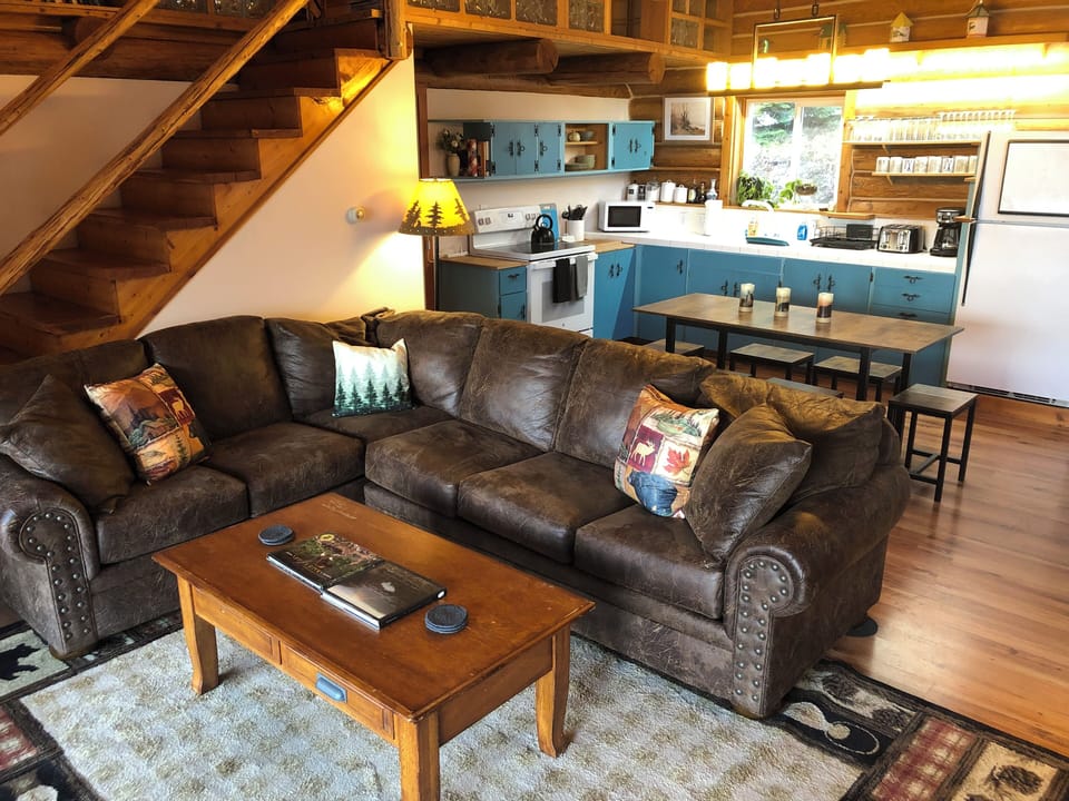 main level living room with kitchen/dining stairs to loft with movie projector
