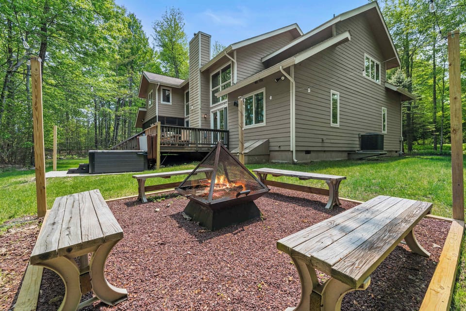 Gather around the fire pit benches in daylight, with the hot tub deck just steps away for an afternoon soak.
